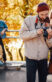 Company of friends relaxing and photographing in autumn park