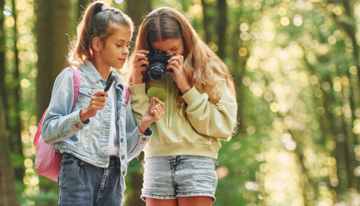 Two friends. Kids in green forest at summer daytime together