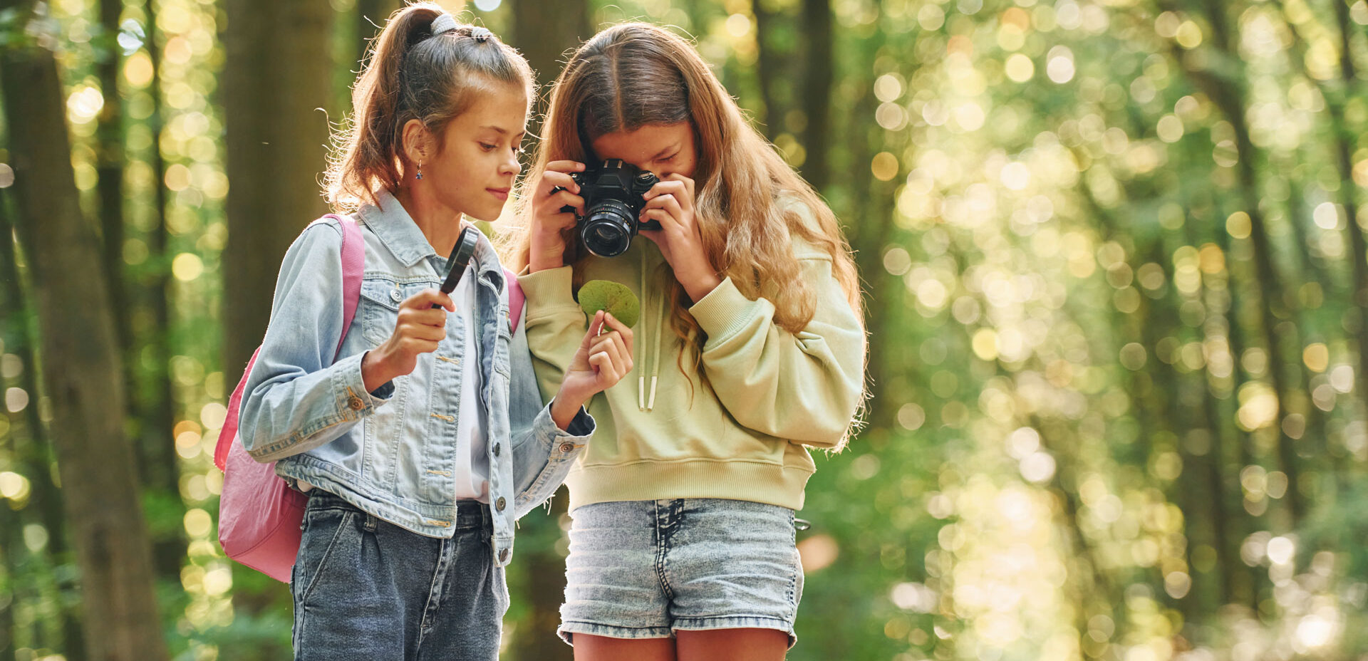 Two friends. Kids in green forest at summer daytime together